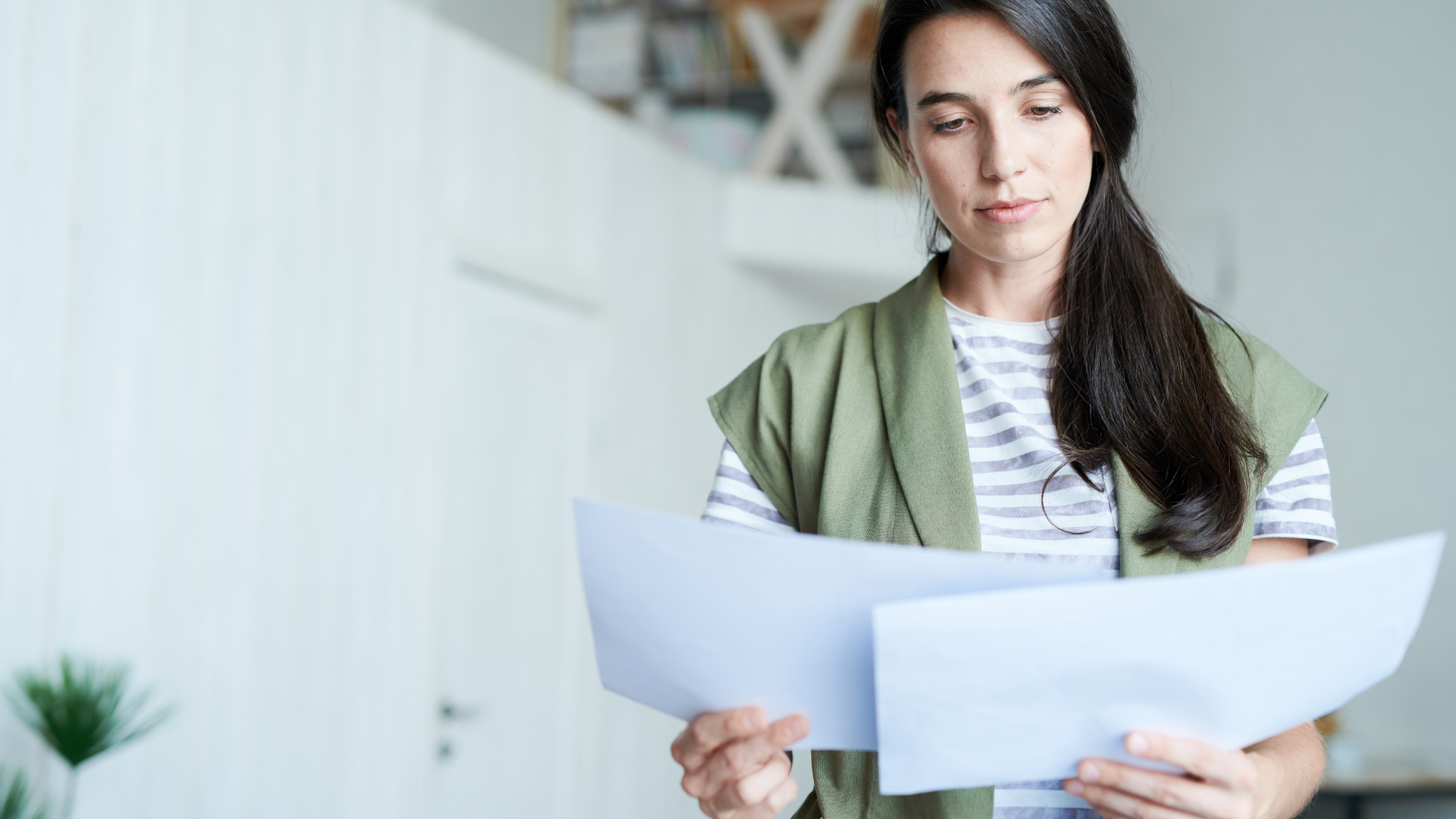 Woman reviewing tax documents at home for an article about tax filing mistakes that could trigger an IRS letter in 2026.
