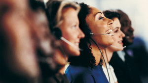Professional tax relief representatives wearing headsets assist clients with IRS tax relief program applications.